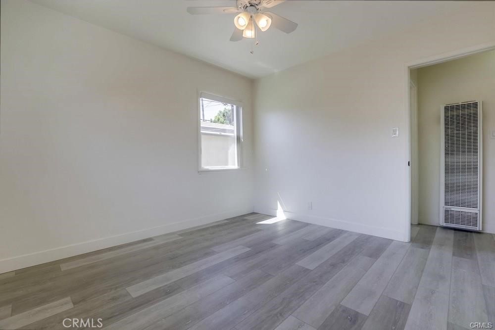 8716 Buckles Street Downey, CA 90241 - Photo 14 of 22 an empty room with wooden floor and windows