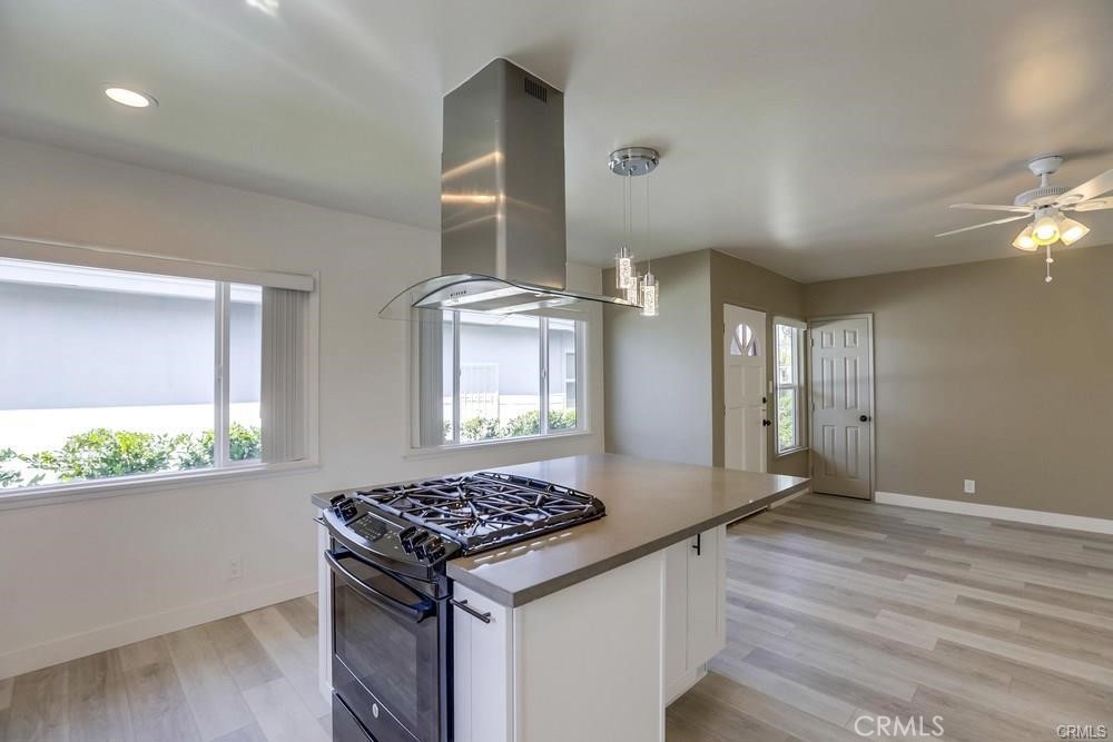 8716 Buckles Street Downey, CA 90241 - Photo 4 of 22 a kitchen with a stove and a wooden floor