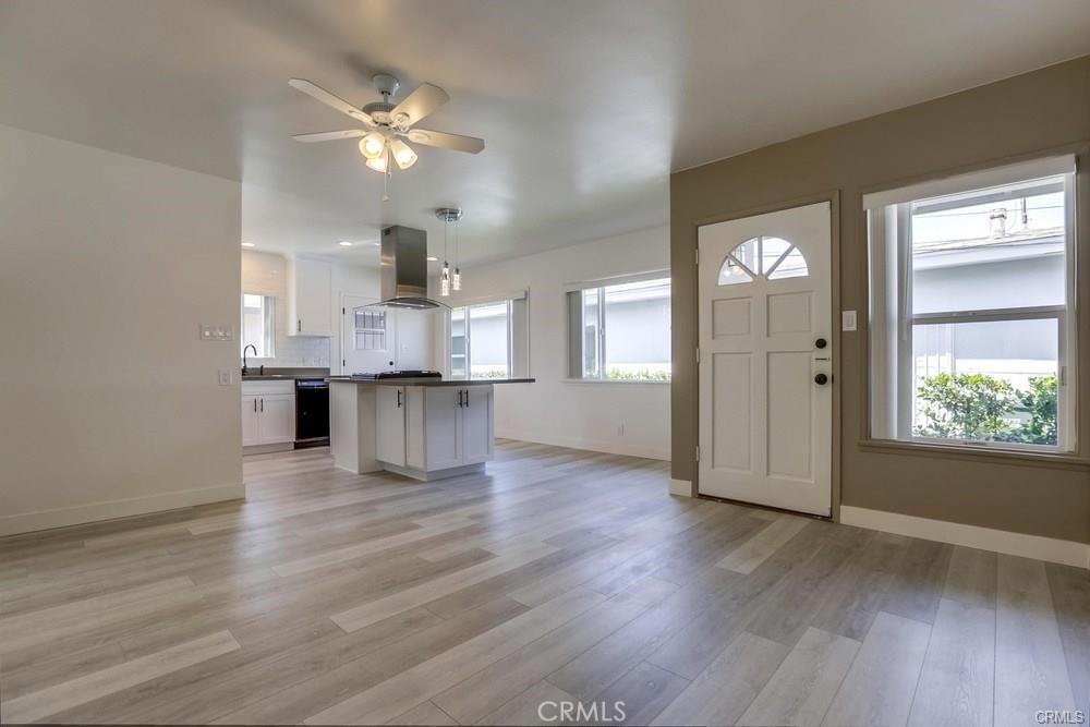 8716 Buckles Street Downey, CA 90241 - Photo 8 of 22 an empty room with wooden floor cabinet and windows