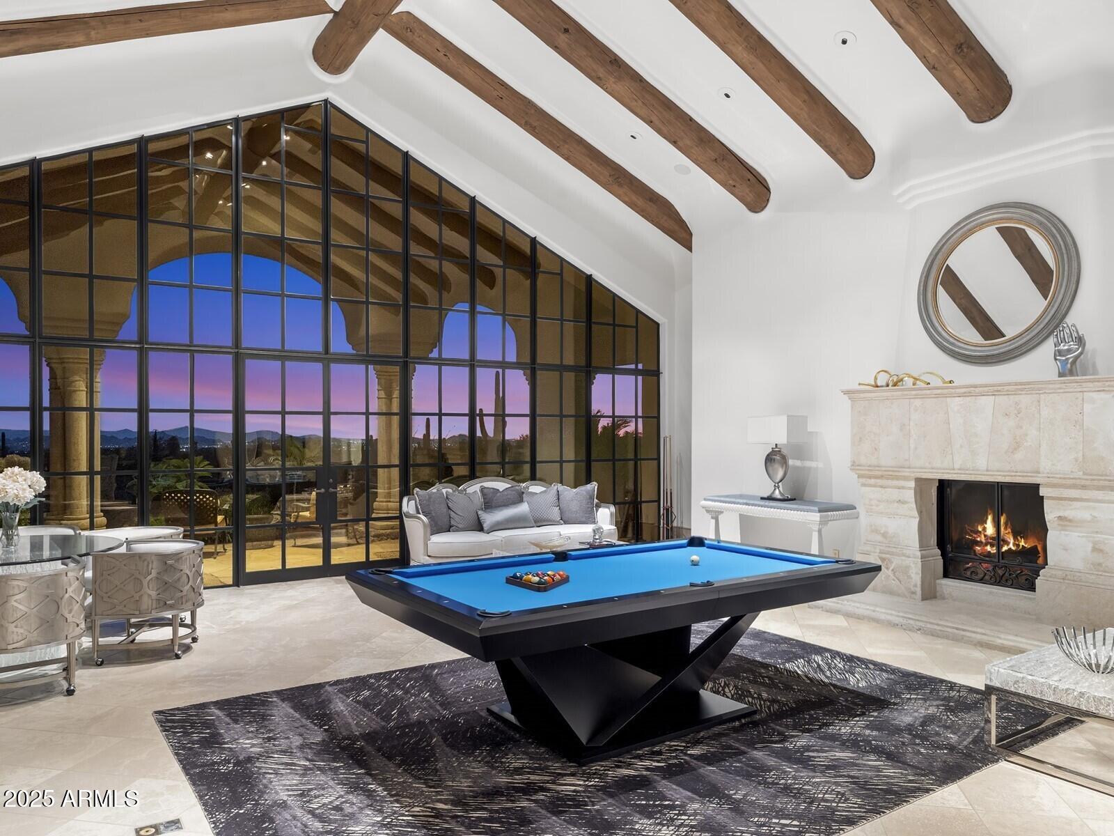 9422 East Happy Valley Road Scottsdale, AZ 85255 - Photo 13 of 78 a living room with a table a rug a fireplace and a floor to ceiling window