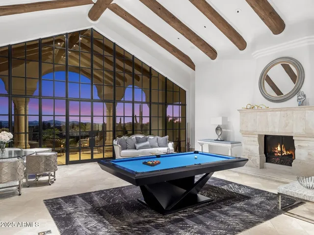 a living room with furniture a fireplace and a floor to ceiling window