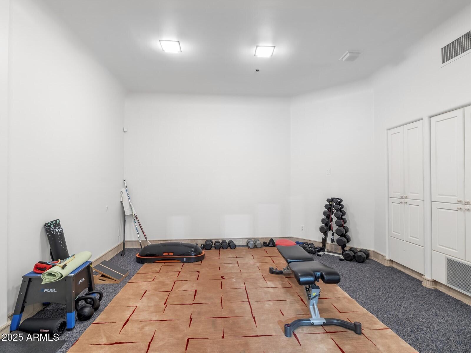 9422 East Happy Valley Road Scottsdale, AZ 85255 - Photo 87 of 99 a room with a wooden floor and gym equipment