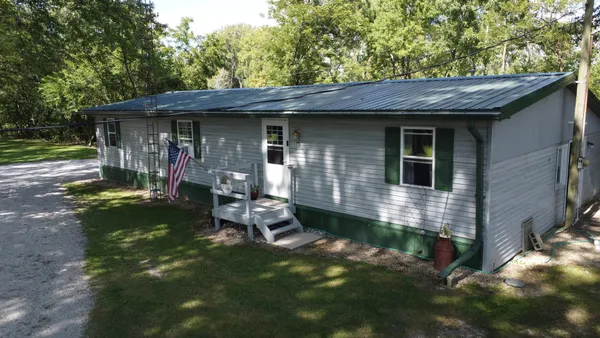 a view of a small house with a yard