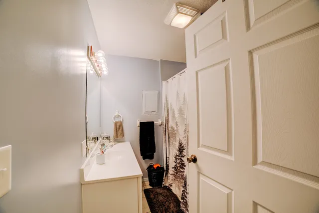 a bathroom with a sink a mirror and shower curtain