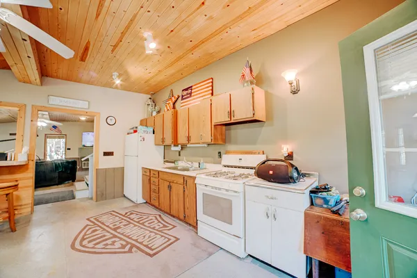 a kitchen that has a lot of cabinets in it and wooden floor