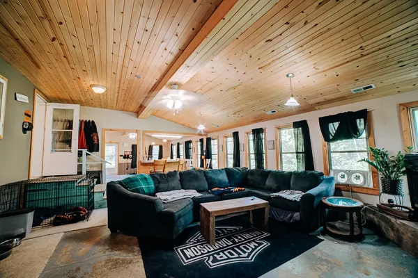 a living room with furniture a flat screen tv and a dining table