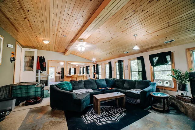 a living room with furniture a flat screen tv and a dining table