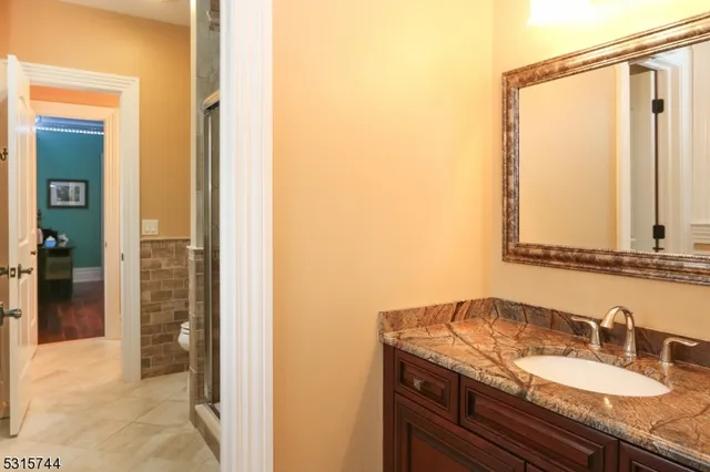 a bathroom with a granite countertop sink and a mirror