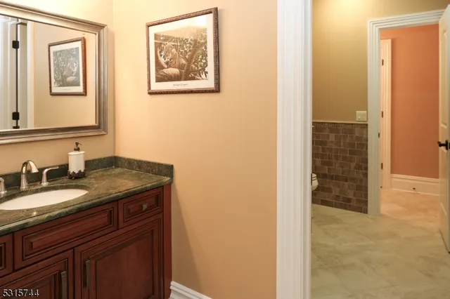 a bathroom with a granite countertop sink a mirror a vanity