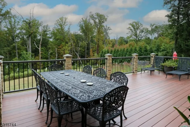 a balcony with wooden floor table and chairs