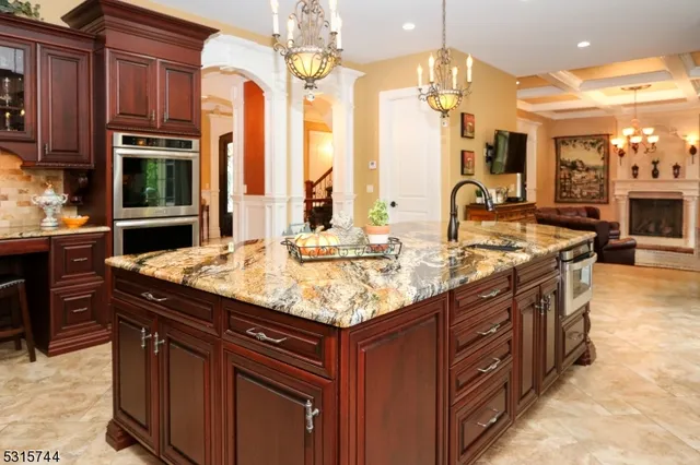 a kitchen with stainless steel appliances granite countertop a sink a stove and a wooden cabinets