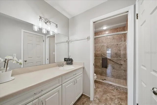a bathroom with a shower sink and mirror