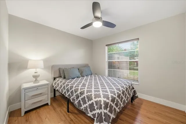 a bedroom with a bed and wooden floor