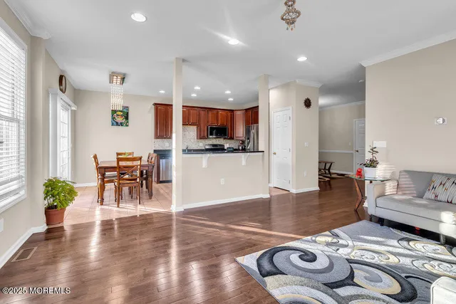 a living room with furniture and a dining table with kitchen view