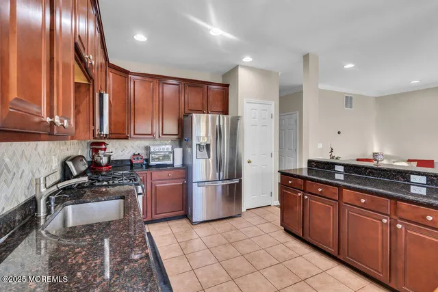 a kitchen with a sink a refrigerator and cabinets