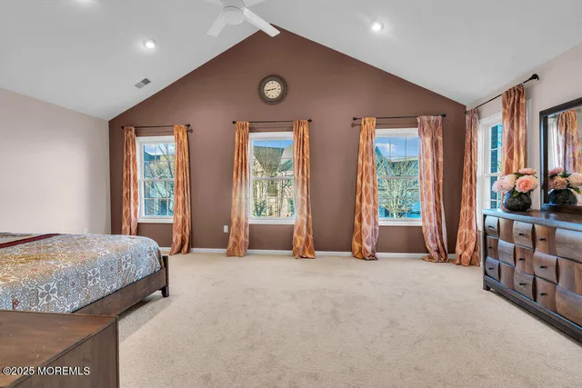 a spacious bedroom with a bed and a dresser with rug