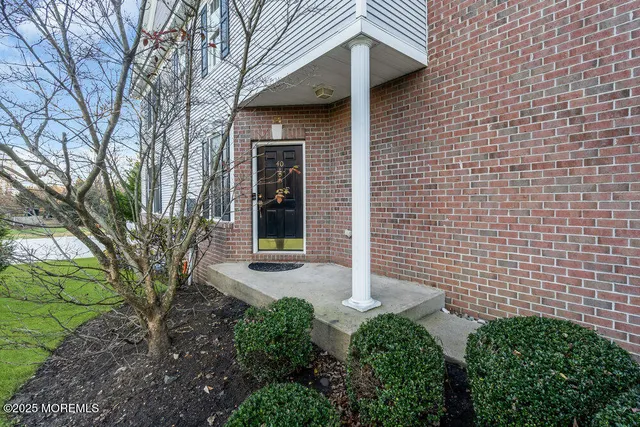a view of a brick house with a small yard and plants
