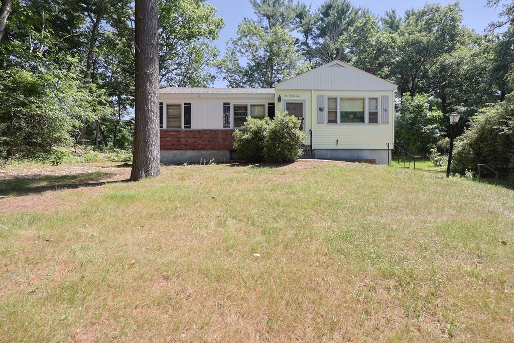 a front view of a house with yard and trees