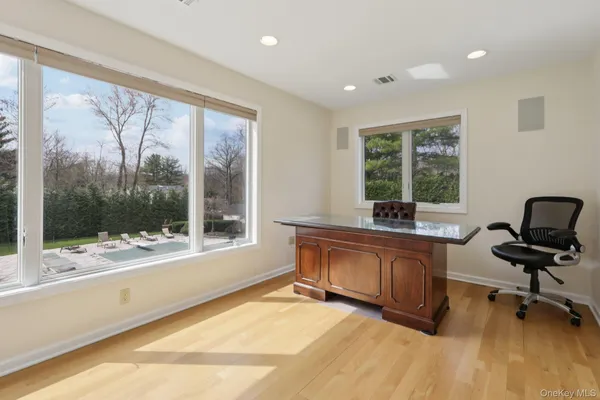 a view of a workspace with wooden floor and a window