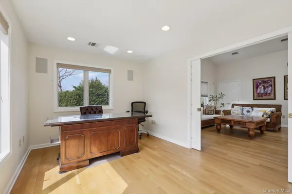 a view of a workspace with furniture and a window