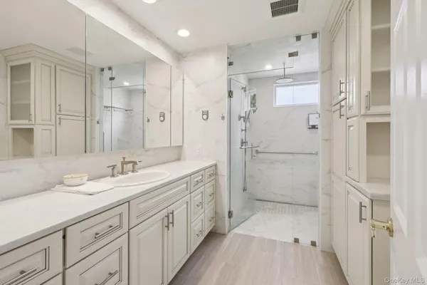 a bathroom with a double vanity sink mirror double and shower