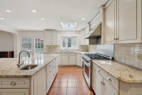 a kitchen with granite countertop a sink stainless steel appliances and cabinets