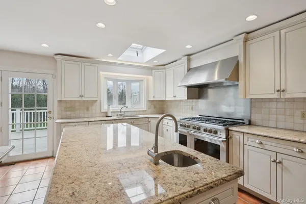 a kitchen with stainless steel appliances granite countertop a stove a sink and a refrigerator
