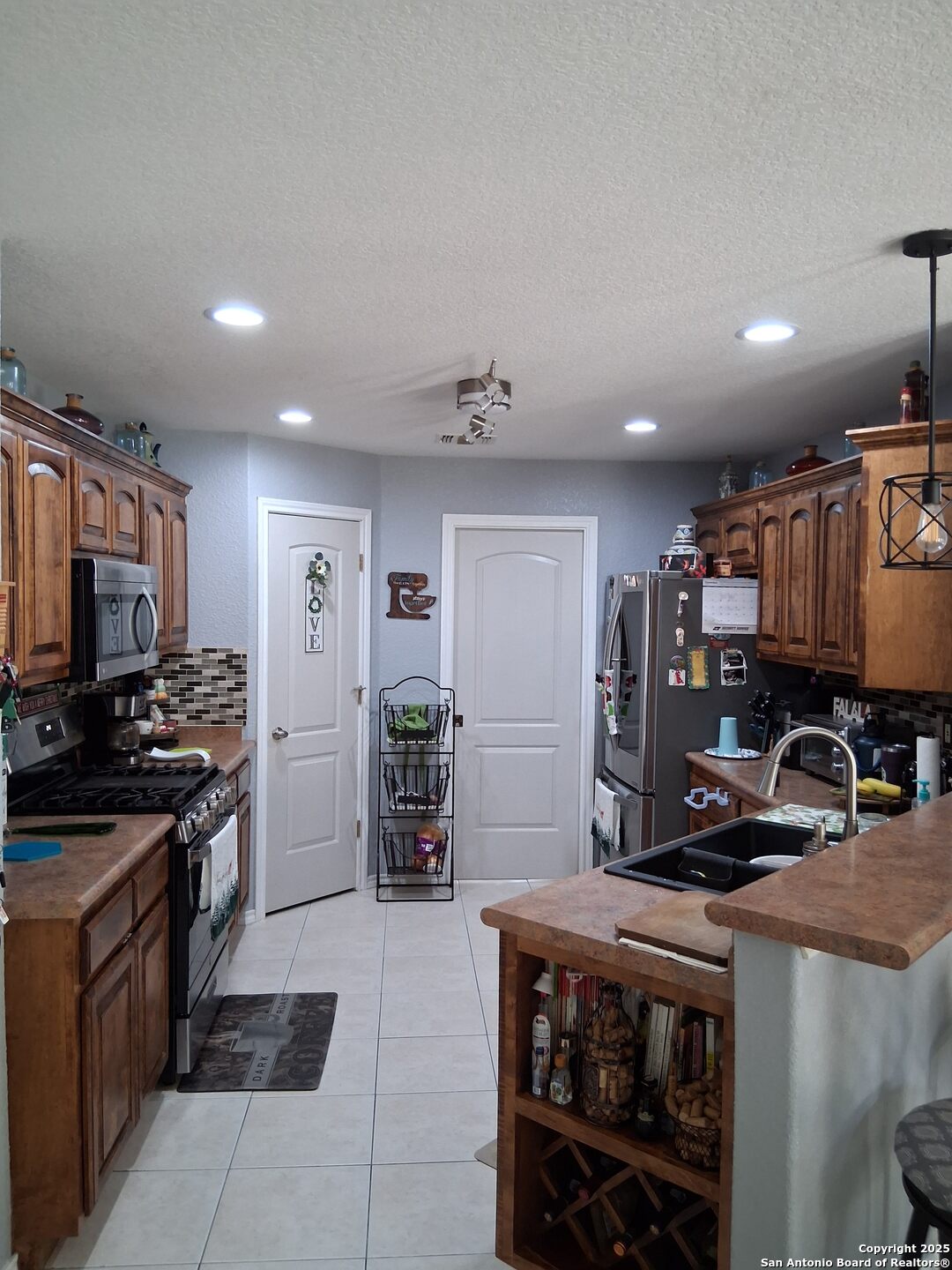 7061 Devonshire Drive Spring Branch, TX 78070 - Photo 19 of 52 a kitchen with stainless steel appliances a stove a sink a microwave a refrigerator and cabinets
