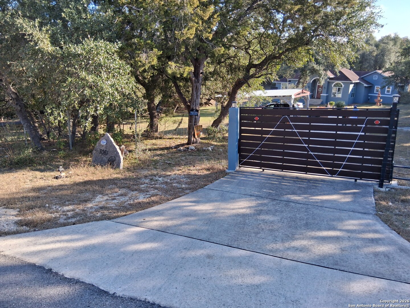 7061 Devonshire Drive Spring Branch, TX 78070 - Photo 43 of 52 a view of a house with a yard and large tree