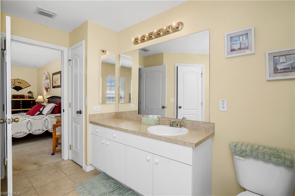 113 Northeast 29th Street Cape Coral, FL 33909 - Photo 11 of 19 a en suite bathroom with a granite countertop sink and a mirror