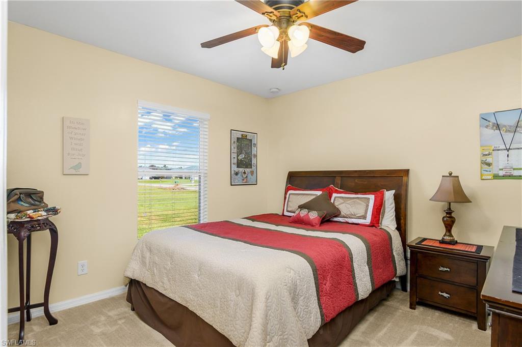 113 Northeast 29th Street Cape Coral, FL 33909 - Photo 12 of 19 a bedroom with a bed and a chandelier