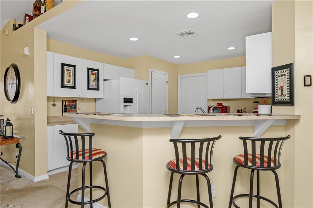 113 Northeast 29th Street Cape Coral, FL 33909 - Photo 8 of 19 a kitchen with stainless steel appliances granite countertop a table and chairs in it