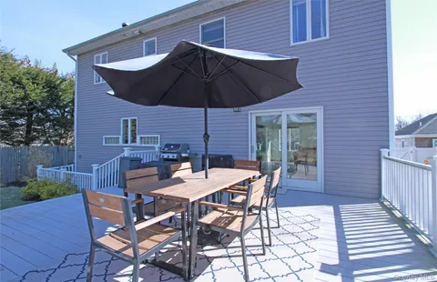 a patio with a table and chairs under an umbrella