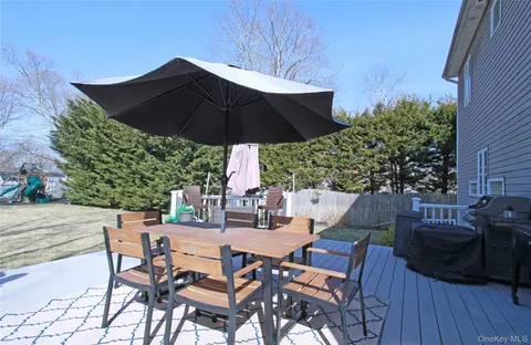a view of a patio with table and chairs under an umbrella