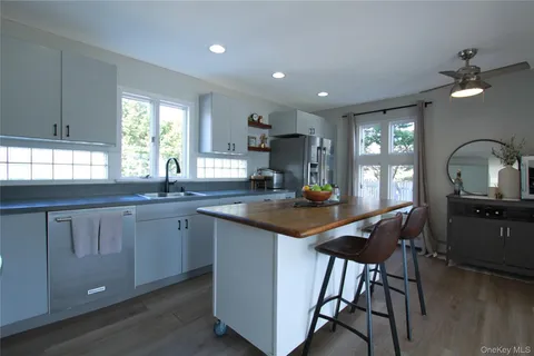 a kitchen with sink a window and chairs