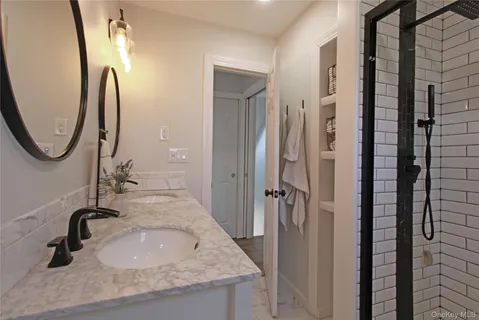 a bathroom with a granite countertop sink and mirror