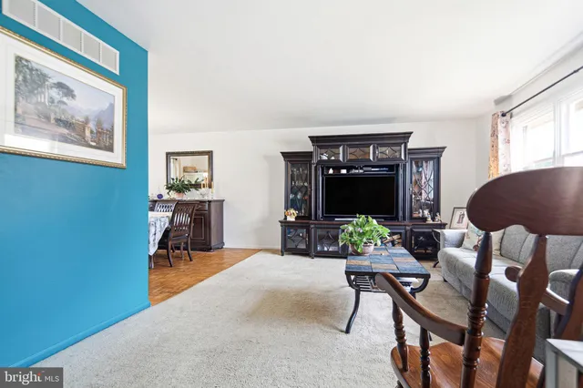 a kitchen with stainless steel appliances granite countertop a refrigerator a stove a sink dishwasher and a dining table with wooden floor