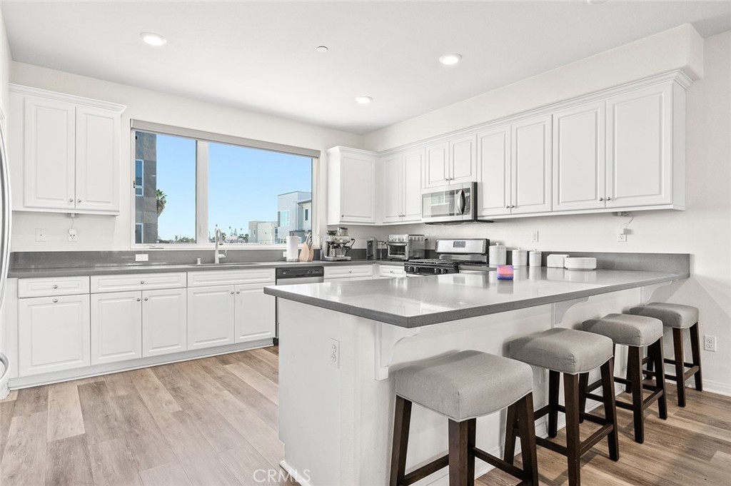 a kitchen with granite countertop white cabinets and stainless steel appliances