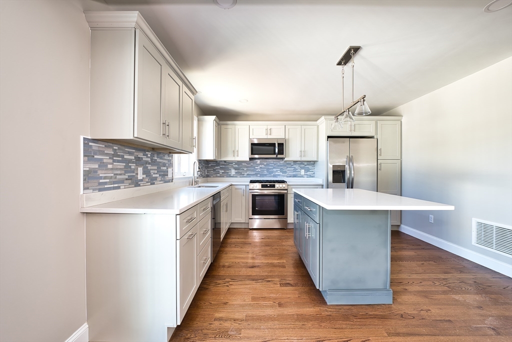 124 Downing Street Fall River, MA 02723 - Photo 12 of 33 a kitchen with stainless steel appliances a sink a stove top oven a counter space and cabinets