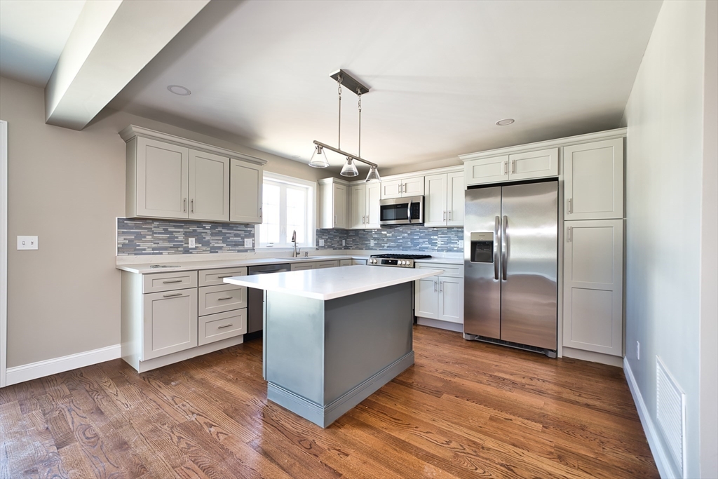124 Downing Street Fall River, MA 02723 - Photo 13 of 33 a kitchen with kitchen island granite countertop a sink cabinets stainless steel appliances and a window