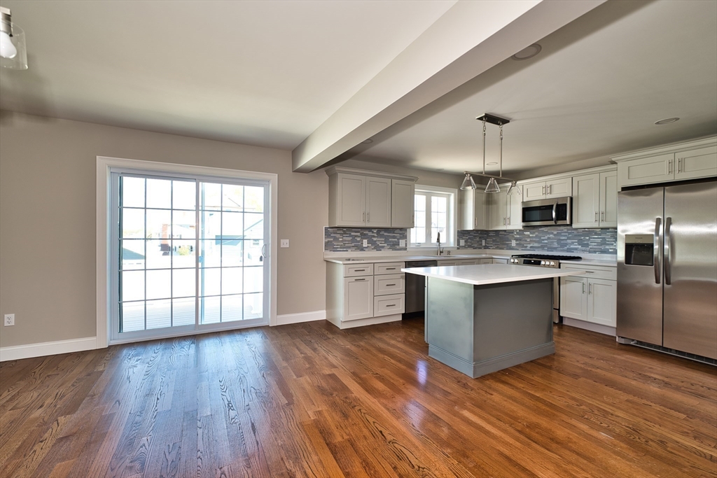 124 Downing Street Fall River, MA 02723 - Photo 14 of 33 a large kitchen with wooden floors stainless steel appliances and window