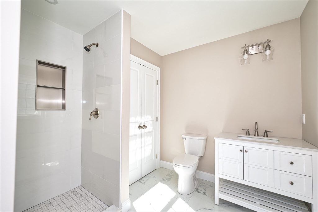124 Downing Street Fall River, MA 02723 - Photo 22 of 33 a bathroom with a toilet sink a shower and a mirror