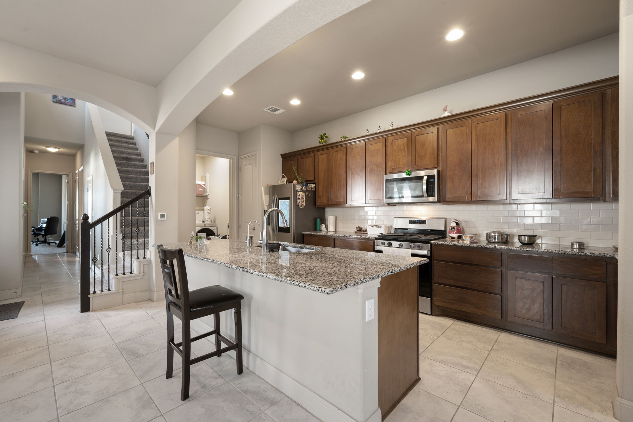 205 Clubhouse Drive, Unit G Georgetown, TX 78628 - Photo 6 of 40 a kitchen with stainless steel appliances granite countertop a stove top oven a sink a dining table and chairs