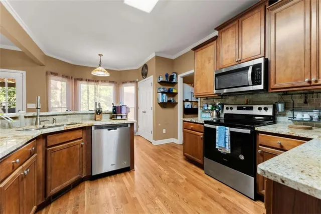 a large kitchen with stainless steel appliances granite countertop a stove a sink dishwasher and a refrigerator