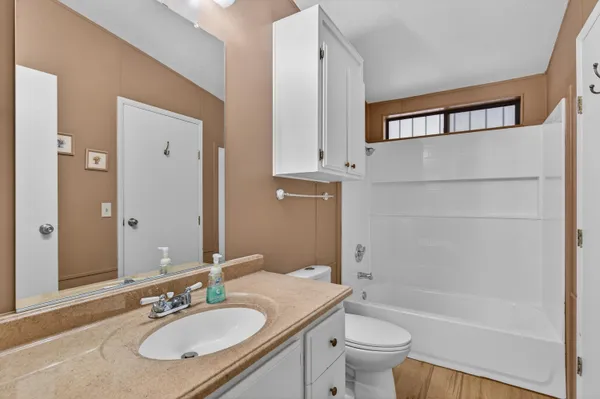 a bathroom with a granite countertop sink toilet and shower
