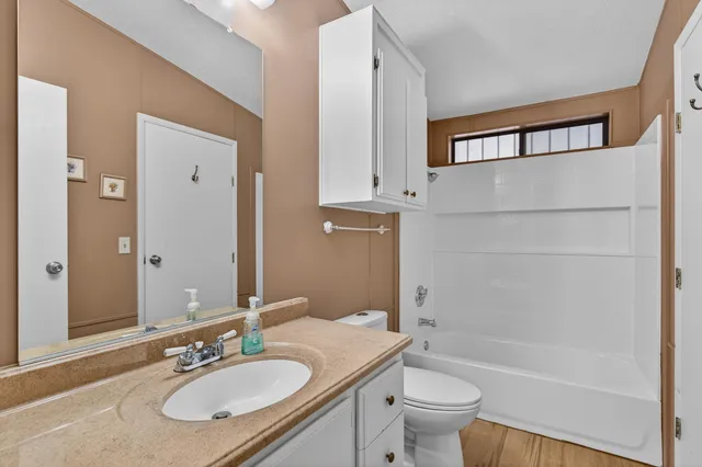 a bathroom with a granite countertop sink toilet and shower
