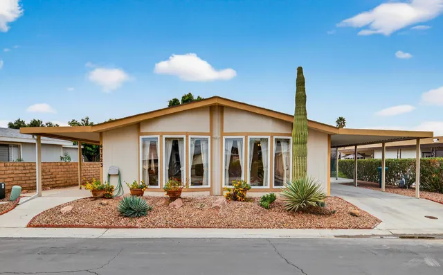 a view of a house with a yard and potted plants