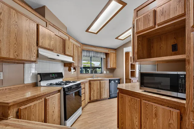 a kitchen with stainless steel appliances granite countertop a stove and a microwave