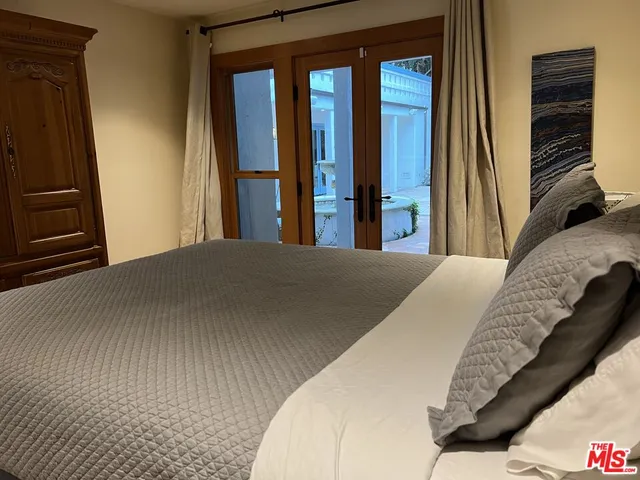 a bedroom with a bed and a flat tv screen on dresser