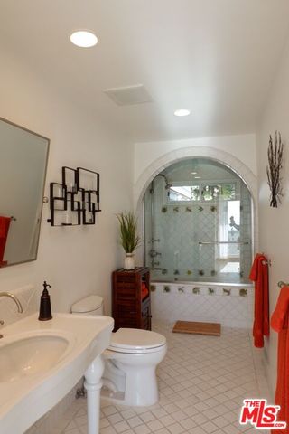 a bathroom with a sink a mirror and a potted plant